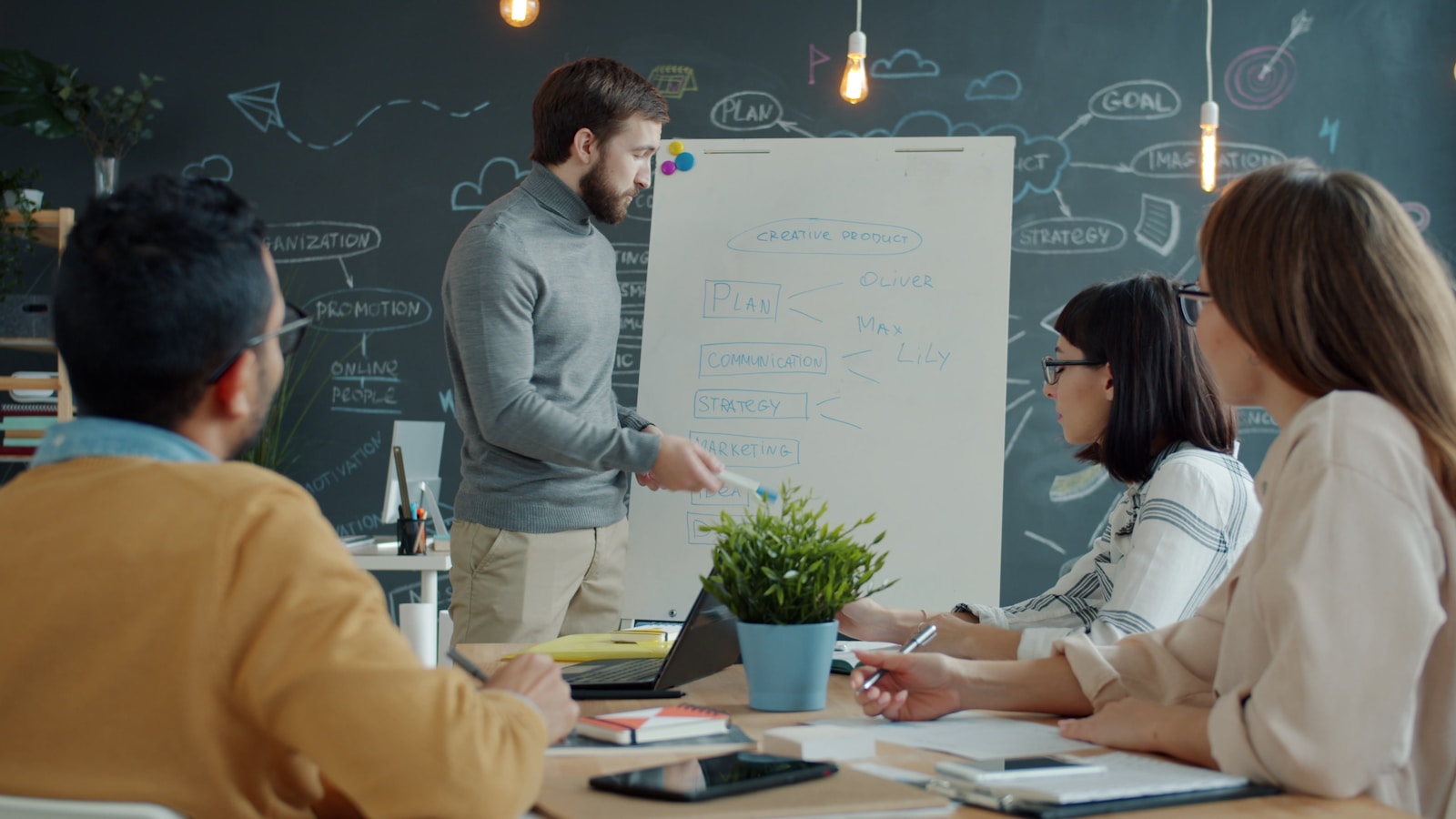 Delivery team working through a plan at a whiteboard in an office